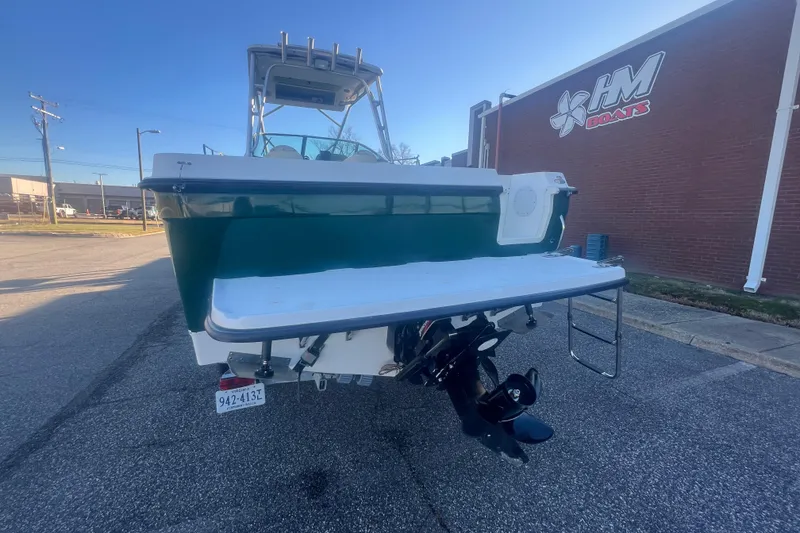 Slide: The Image of 2004 Trophy 2352 Walkaround boat, rear view, parked near a brick building. - 4