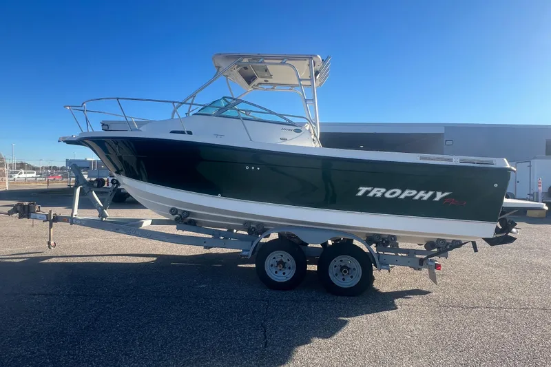 Slide: The Image of 2004 Trophy 2352 Walkaround boat on trailer, parked outdoors under clear blue sky. - 41