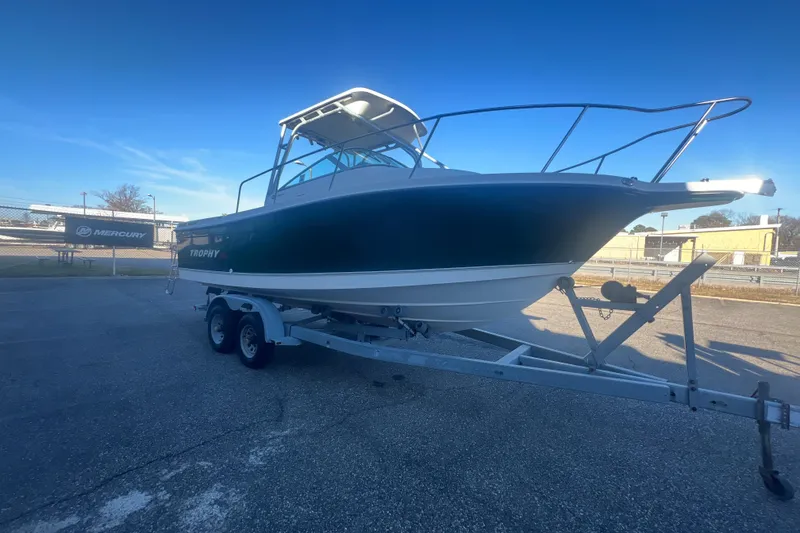 Slide: The Image of 2004 Trophy 2352 Walkaround boat on trailer under clear blue sky. - 9