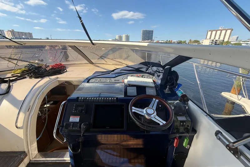 Slide: The Image of Helm of 2002 Viking Princess V50 yacht with cityscape background. - 10