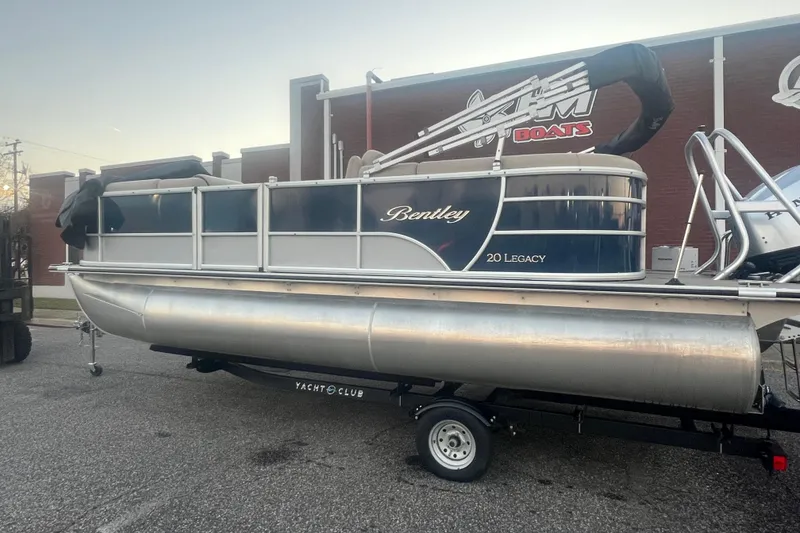 Slide: The Image of 2024 Bentley Pontoons 200 Navigator pontoon boat on trailer, parked outdoors. - 2