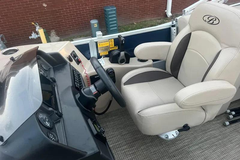 Slide: The Image of 2024 Bentley Pontoons 200 Navigator helm with beige captain's chair and control panel. - 21