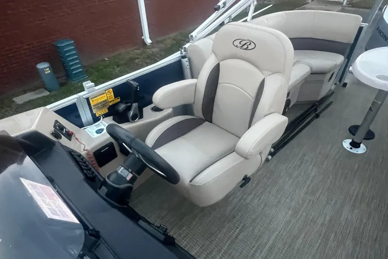Slide: The Image of 2024 Bentley Pontoons 200 Navigator interior with plush captain's chair and steering console. - 29