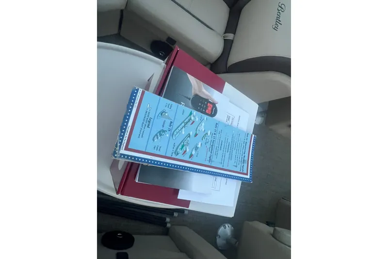 Slide: The Image of 2024 Bentley Pontoons 200 Navigator interior with manuals and documents on seat. - 34