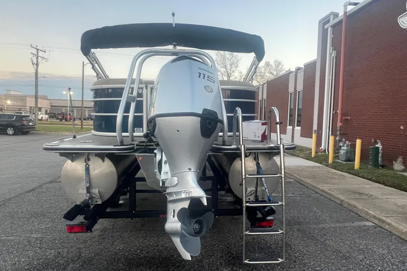 Slide: The Image of 2024 Bentley Pontoons 200 Navigator with outboard motor and ladder, parked outdoors. - 5