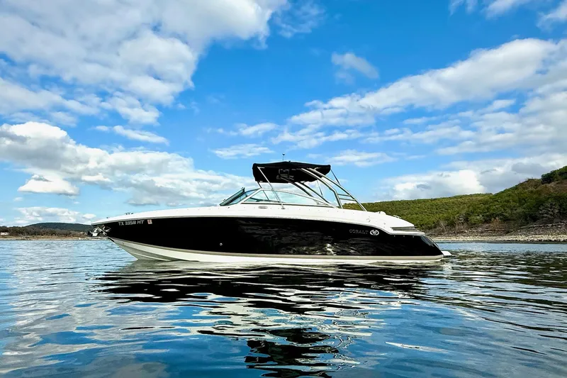 Slide: The Image of 2011 Cobalt 276 boat on calm water under a blue sky with clouds. - 1