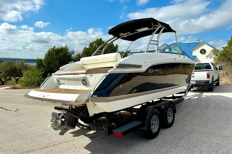 Slide: The Image of 2011 Cobalt 276 boat on trailer, parked outdoors under a blue sky. - 12
