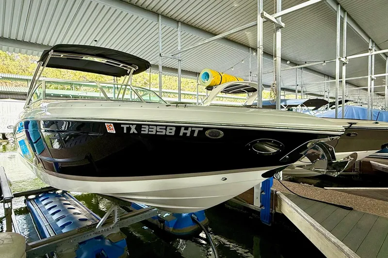 Slide: The Image of 2011 Cobalt 276 boat docked in a covered marina. - 16