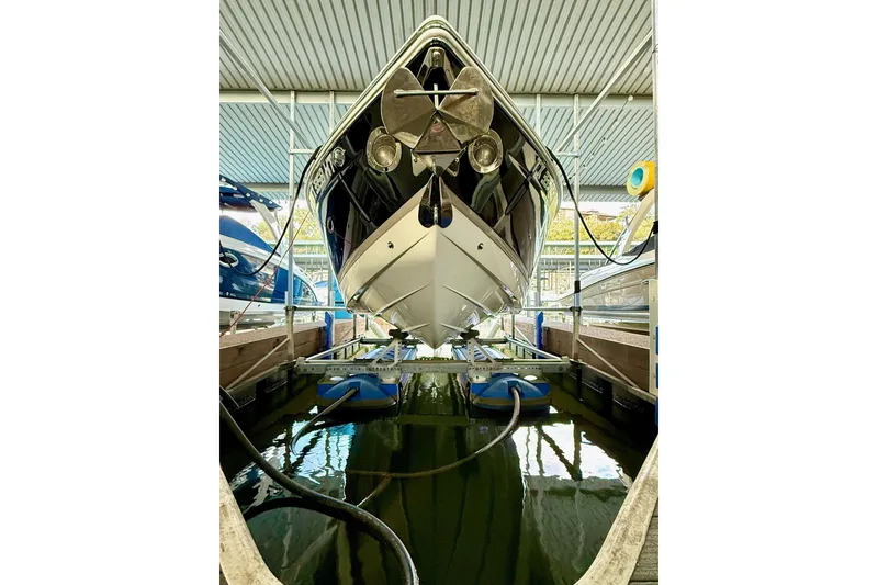 Slide: The Image of 2011 Cobalt 276 boat docked in a covered marina, viewed from the front. - 19