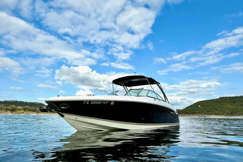 Slide: The Image of 2011 Cobalt 276 boat on water under blue sky with clouds. - 2