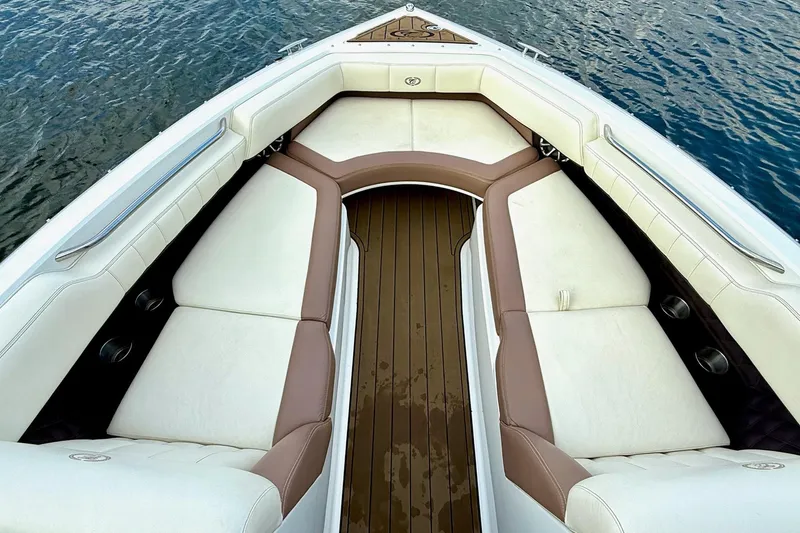 Slide: The Image of 2011 Cobalt 276 boat interior with white and brown seating, on calm water. - 24