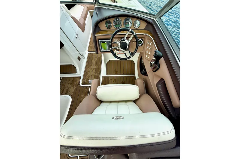 Slide: The Image of 2011 Cobalt 276 boat interior with steering wheel and dashboard, featuring elegant wood accents. - 27