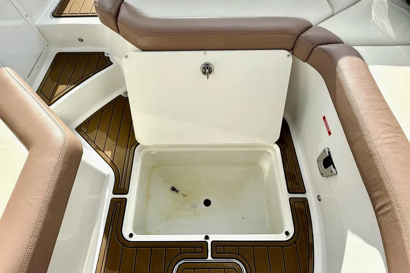 Slide: The Image of 2011 Cobalt 276 boat interior with storage compartment and cushioned seating. - 32