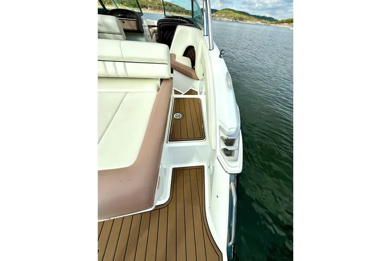 Slide: The Image of 2011 Cobalt 276 boat with white and tan seating, docked on calm water. - 33