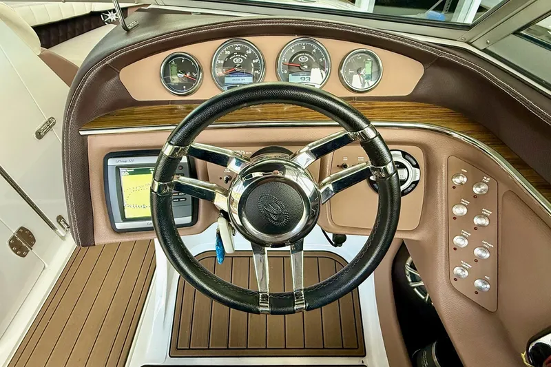 Slide: The Image of Steering wheel and dashboard of a 2011 Cobalt 276 boat with gauges and controls. - 35