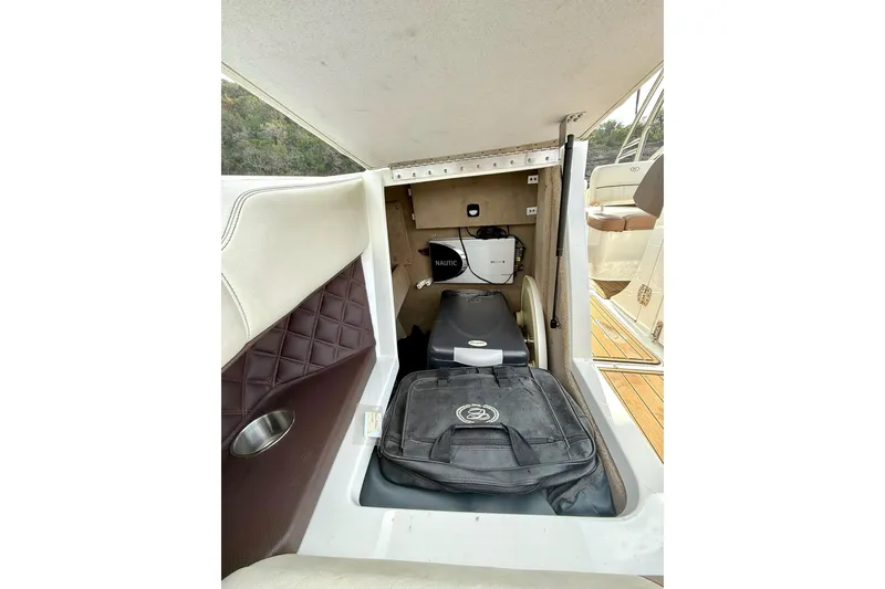 Slide: The Image of 2011 Cobalt 276 boat interior storage compartment with equipment and bag. - 36