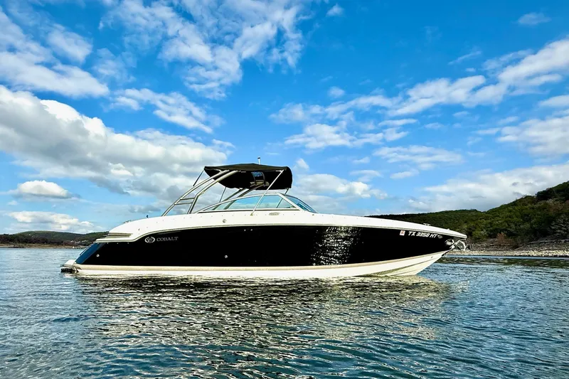 Slide: The Image of 2011 Cobalt 276 boat on calm water under a blue sky with clouds. - 6