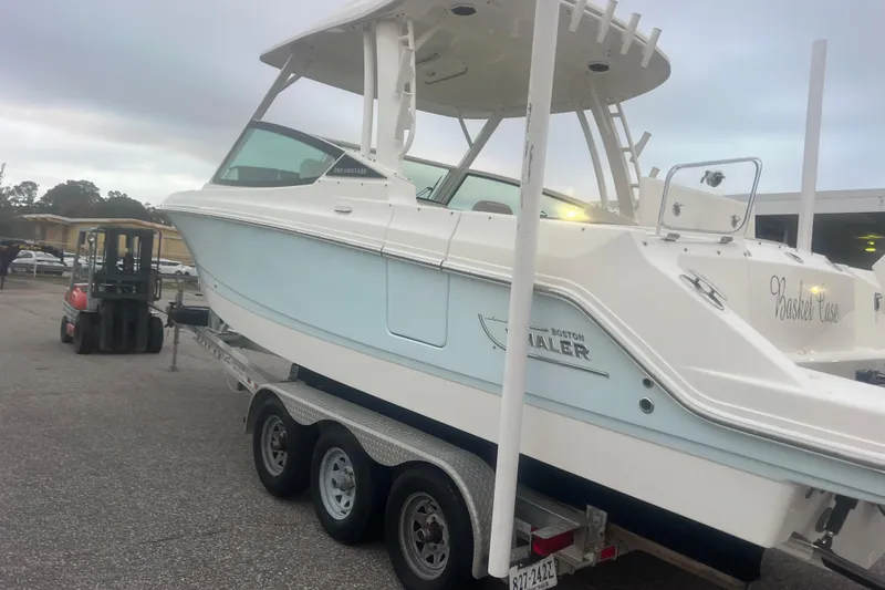Slide: The Image of 2023 Boston Whaler 280 Vantage boat on trailer in parking lot. - 24