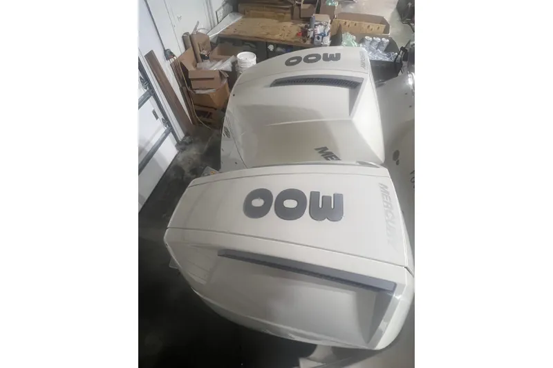 Slide: The Image of 2023 Boston Whaler 280 Vantage with twin Mercury outboard engines in a garage setting. - 55