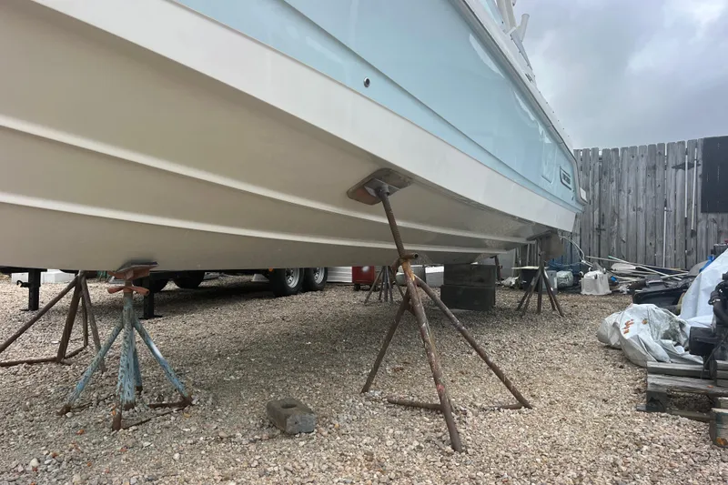Slide: The Image of 2023 Boston Whaler 280 Vantage boat on stands in a gravel yard. - 61