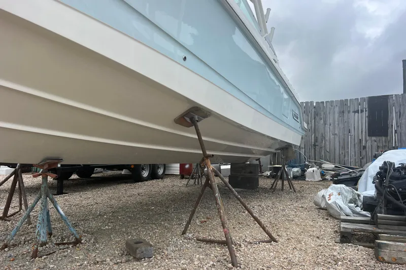 Slide: The Image of 2023 Boston Whaler 280 Vantage boat on stands in a gravel yard. - 63