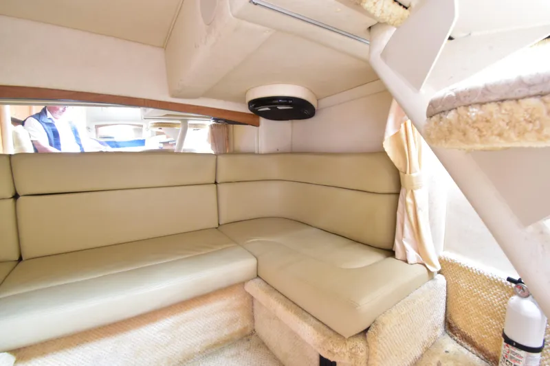 Slide: The Image of Interior of 2006 Sea Ray 320 Sundancer with beige seating and cozy cabin space. - 12