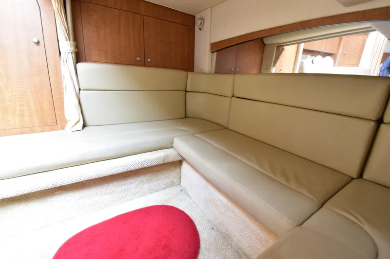 Slide: The Image of Interior of 2006 Sea Ray 320 Sundancer with beige seating and wooden cabinets. - 13
