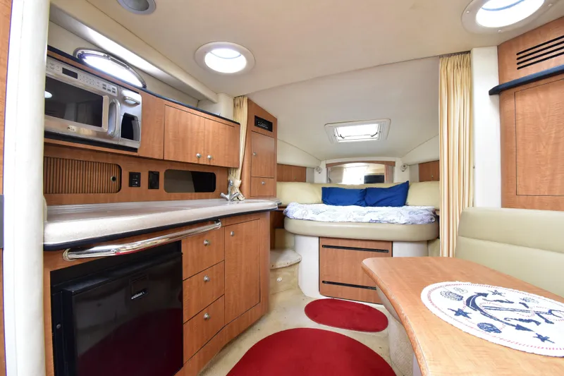 Slide: The Image of Interior of 2006 Sea Ray 320 Sundancer yacht with kitchen and cozy sleeping area. - 15