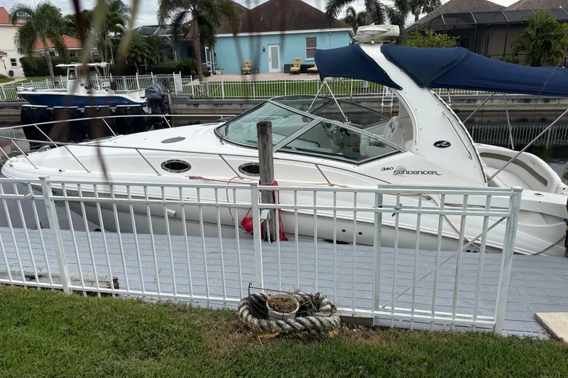 Slide: The Image of 2006 Sea Ray 320 Sundancer docked by a canal, surrounded by palm trees. - 18