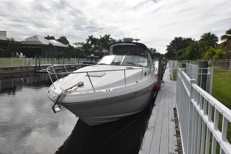 Slide: The Image of 2006 Sea Ray 320 Sundancer docked by a waterfront property. - 2