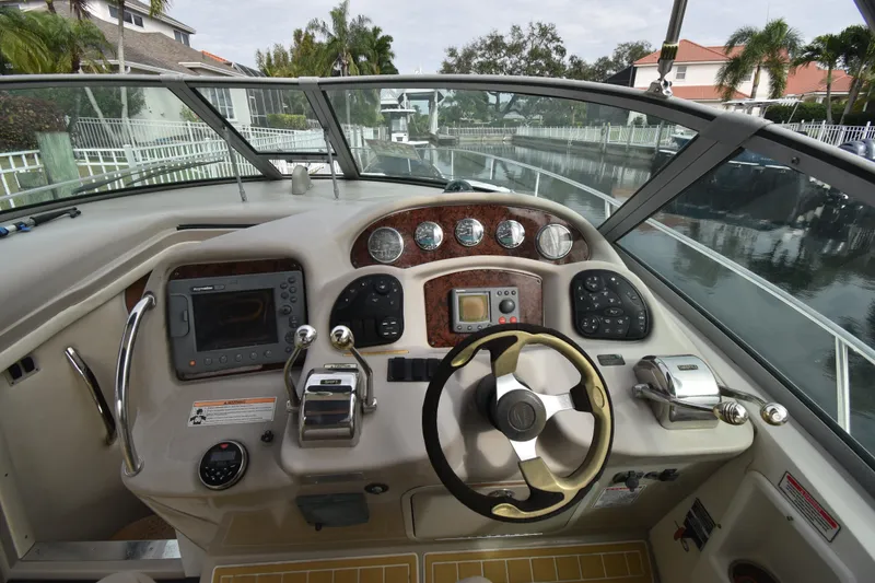 Slide: The Image of 2006 Sea Ray 320 Sundancer helm with steering wheel and navigation controls. - 9