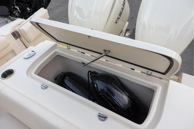 Slide: The Image of 2024 Grady-White Freedom 307 boat storage compartment with fenders and Yamaha engines. - 10