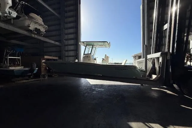 Slide: The Image of 2025 Caymas 28 HB boat console with steering wheel and navigation screens at marina. - 12