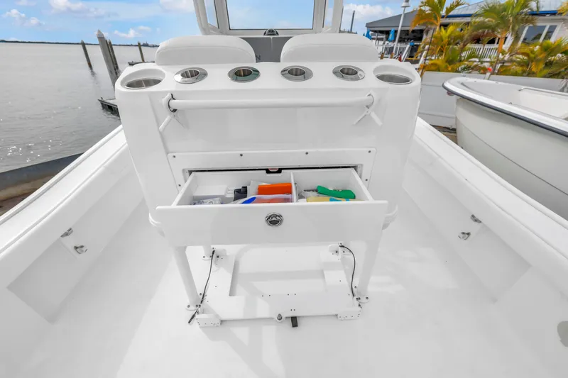 Slide: The Image of 2025 Caymas 28 HB boat with open storage drawer and cup holders on deck. - 13