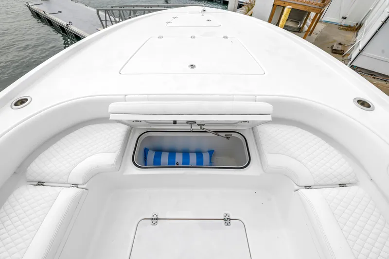 Slide: The Image of 2025 Caymas 28 HB boat with open storage compartment and cushioned seating. - 20