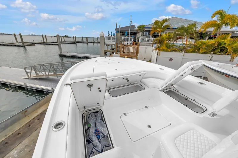 Slide: The Image of 2025 Caymas 28 HB boat docked, featuring spacious deck and storage compartments. - 22