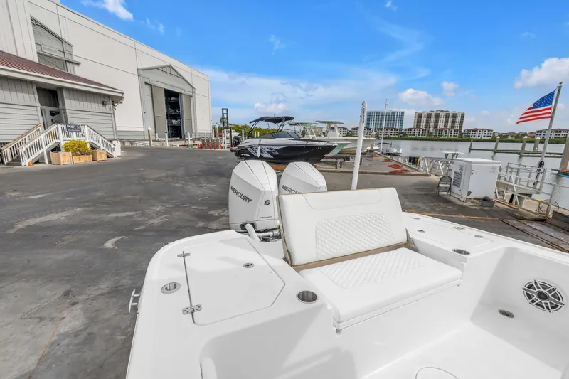 Slide: The Image of 2025 Caymas 28 HB boat docked at marina with Mercury engines, American flag visible. - 27