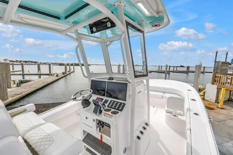 Slide: The Image of 2025 Caymas 28 HB boat at dock, featuring modern helm and spacious seating. - 31