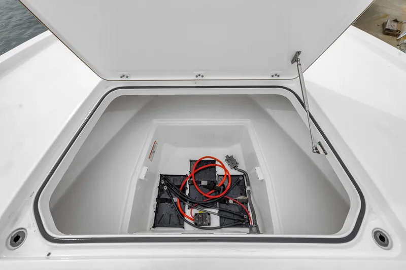 Slide: The Image of Open storage compartment in 2025 Caymas 28 HB boat, featuring wiring and battery setup. - 43