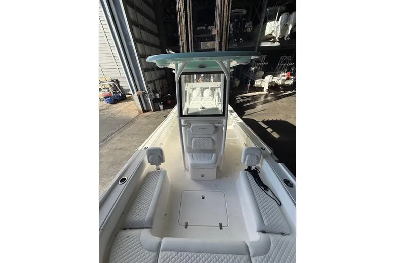 Slide: The Image of 2025 Caymas 28 HB boat in light blue, displayed on a stand outside a warehouse. - 5