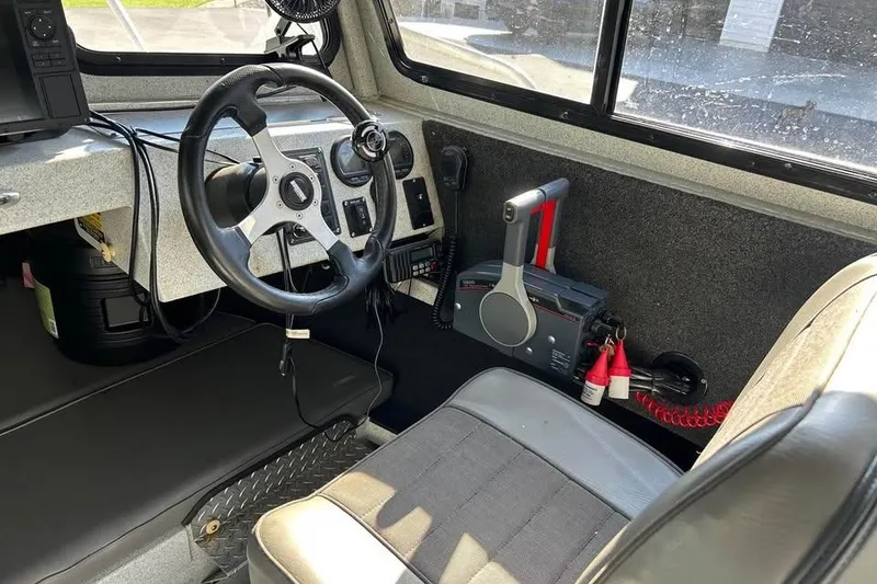 Slide: The Image of Interior of a 2004 Boulton Explorer 24 boat, featuring steering wheel and control panel. - 10