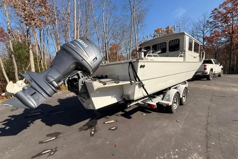 Slide: The Image of 2004 Boulton Explorer 24 boat on trailer with Yamaha outboard motor in wooded area. - 4