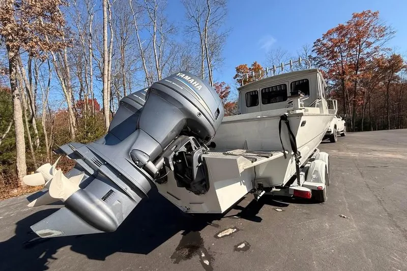 Slide: The Image of 2004 Boulton Explorer 24 boat with Yamaha outboard motor on trailer, surrounded by autumn trees. - 6