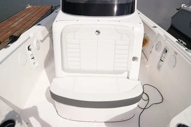 Slide: The Image of The image shows the cockpit of a 2024 Edgewater 262CC boat with white upholstery. - 20
