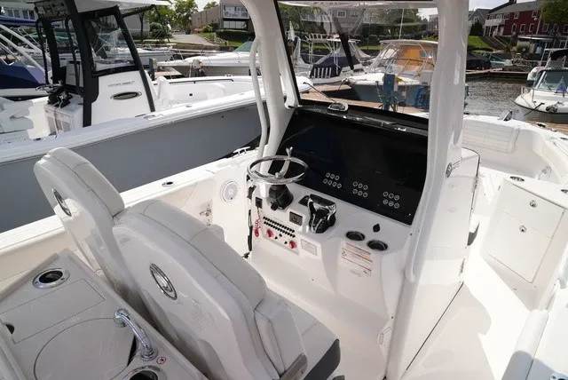 Slide: The Image of The image shows the cockpit of a 2024 Edgewater 262CC boat with modern controls. - 14
