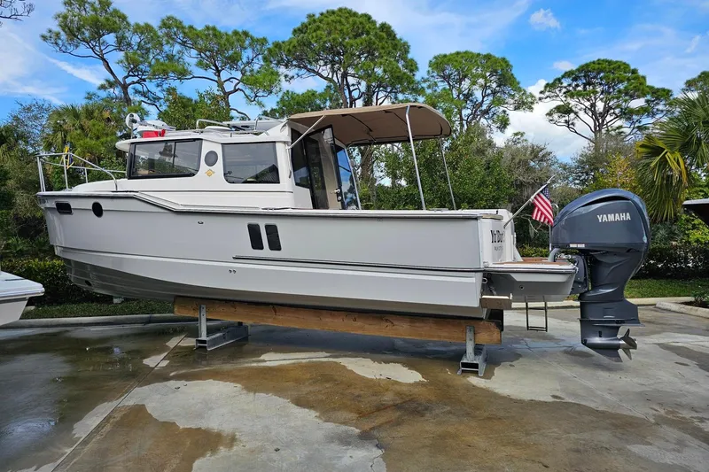 The Image of 2025 Ranger Tugs R-27 boat with Yamaha engine, displayed outdoors on a stand. - 0