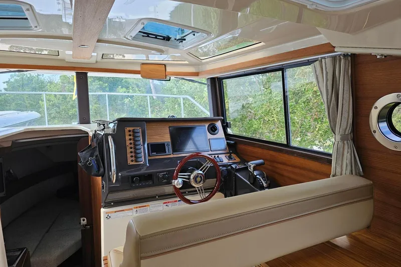 Slide: The Image of Interior of 2025 Ranger Tugs R-27 boat with modern helm and panoramic windows. - 13