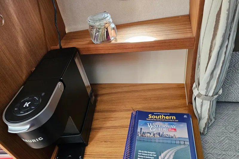 Slide: The Image of ```markdown Keurig coffee maker and waterway guidebook in 2025 Ranger Tugs R-27 interior. ``` - 20