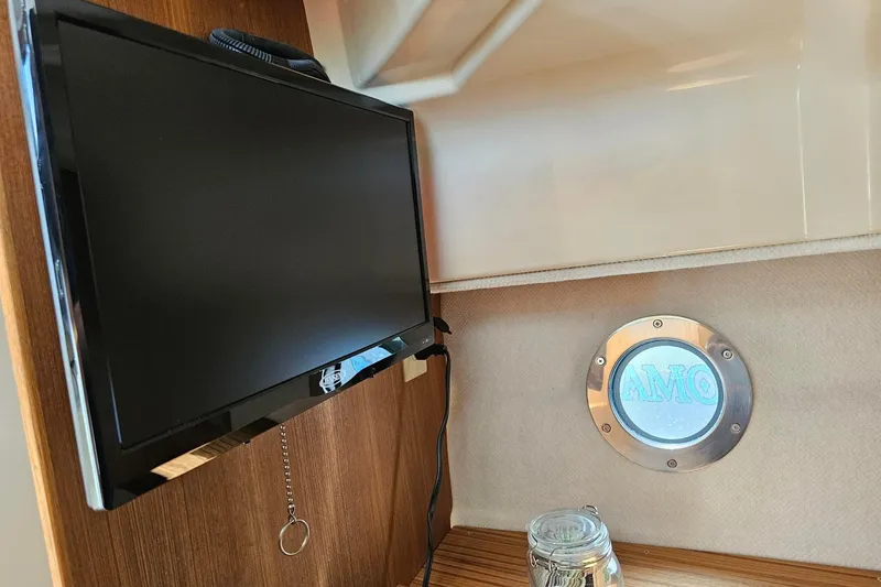 Slide: The Image of 2025 Ranger Tugs R-27 interior with TV and porthole window. - 22