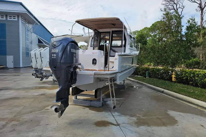 Slide: The Image of 2025 Ranger Tugs R-27 boat with Yamaha 300 V6 engine on display outdoors. - 3